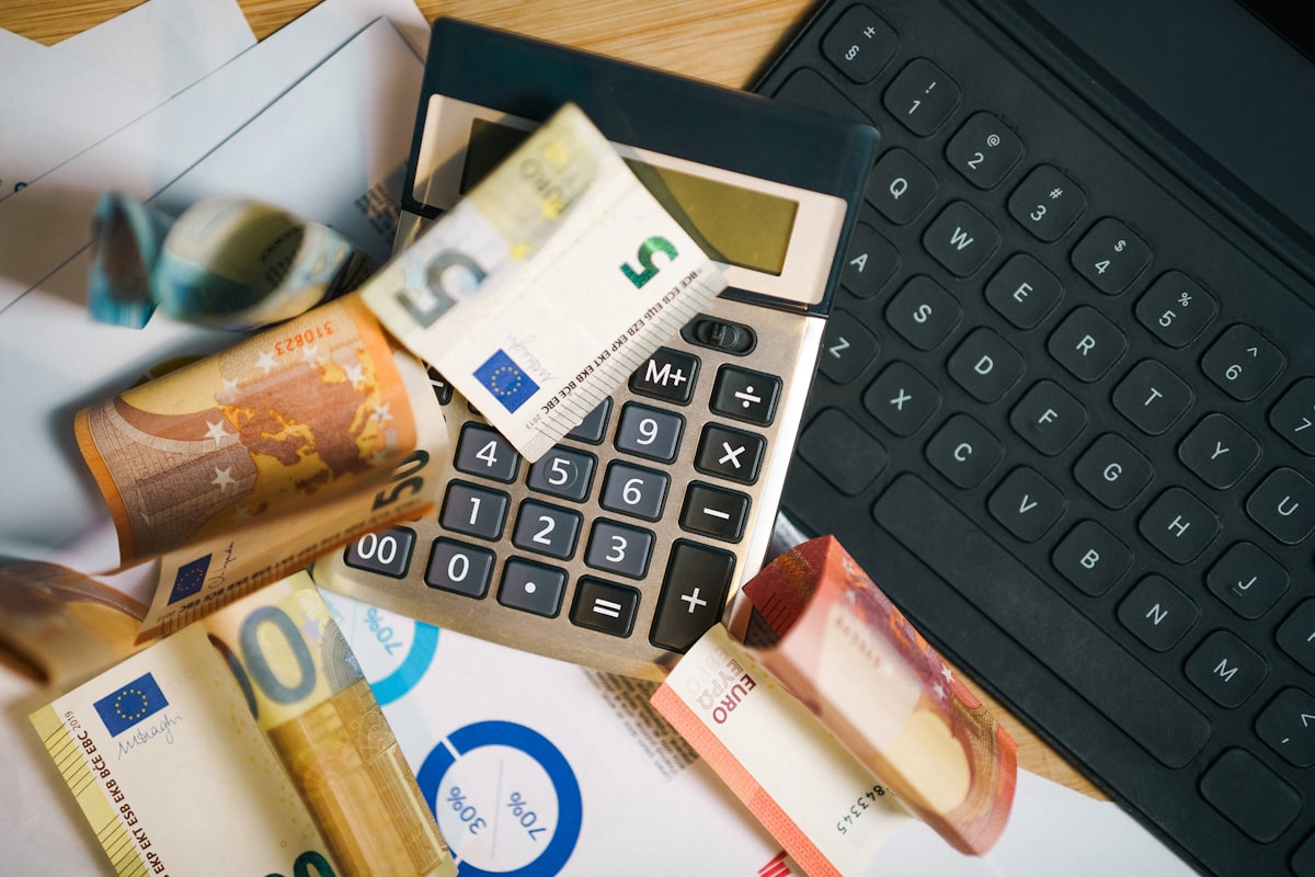 A calculator surrounded by cash on a desk