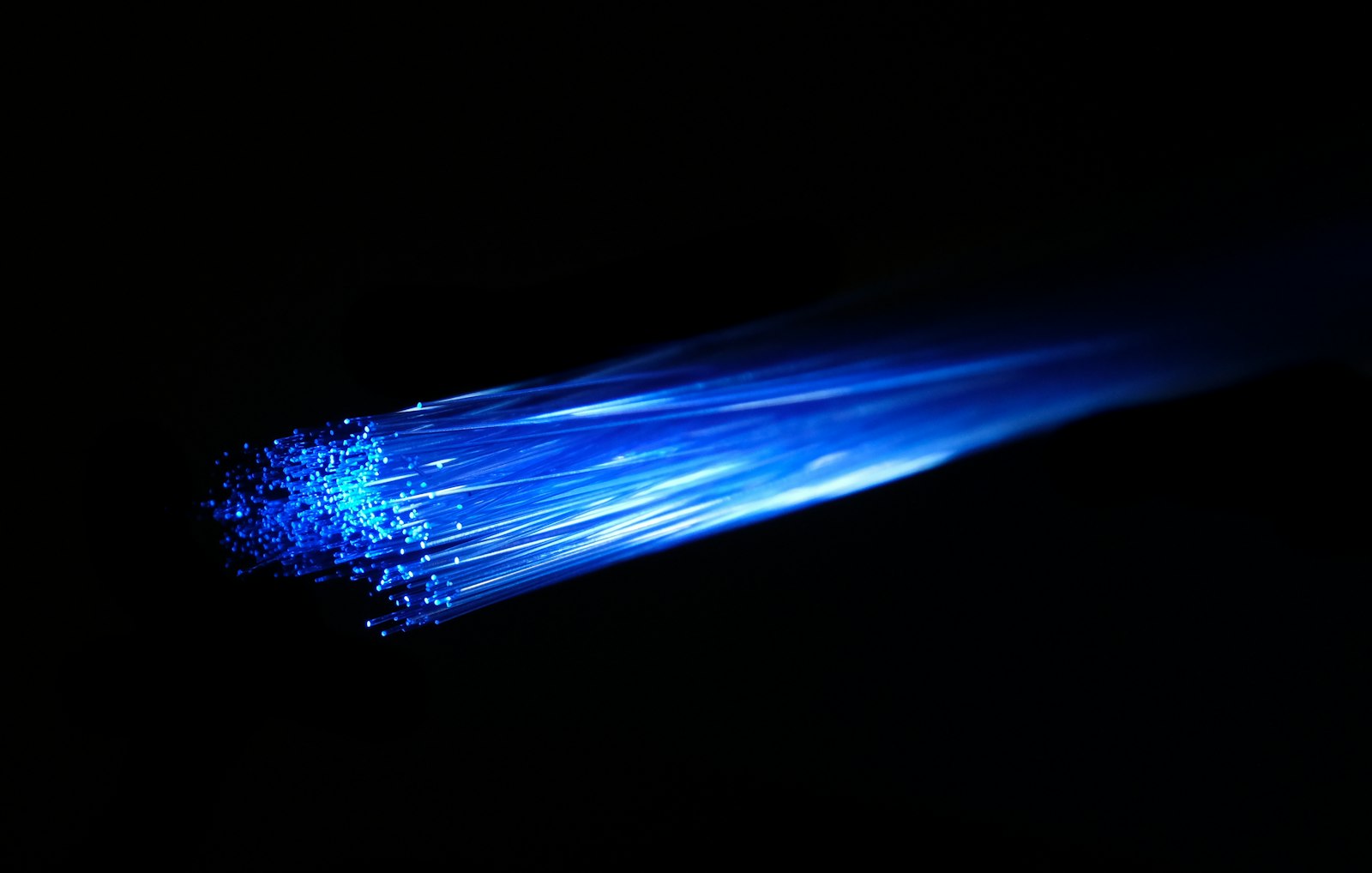 Blue fibre optic light passing through cables in a dark room